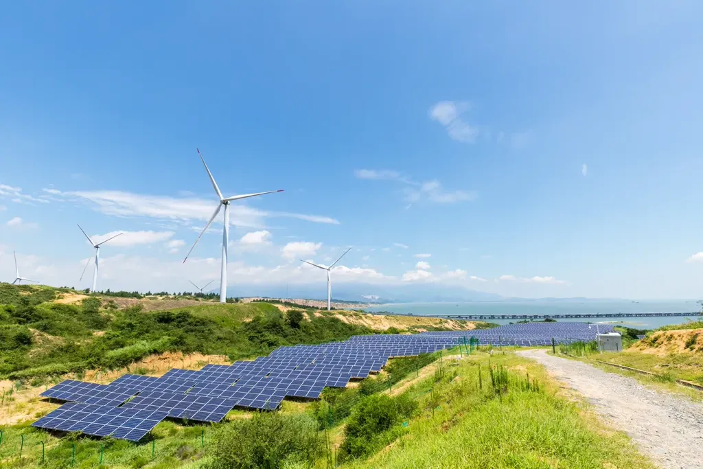 Un paysage avec des éoliennes et des panneaux solaires, illustrant les énergies renouvelables.